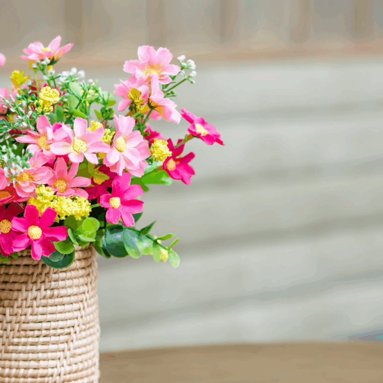 Vibrant pink and yellow artificial flowers in a woven rattan basket