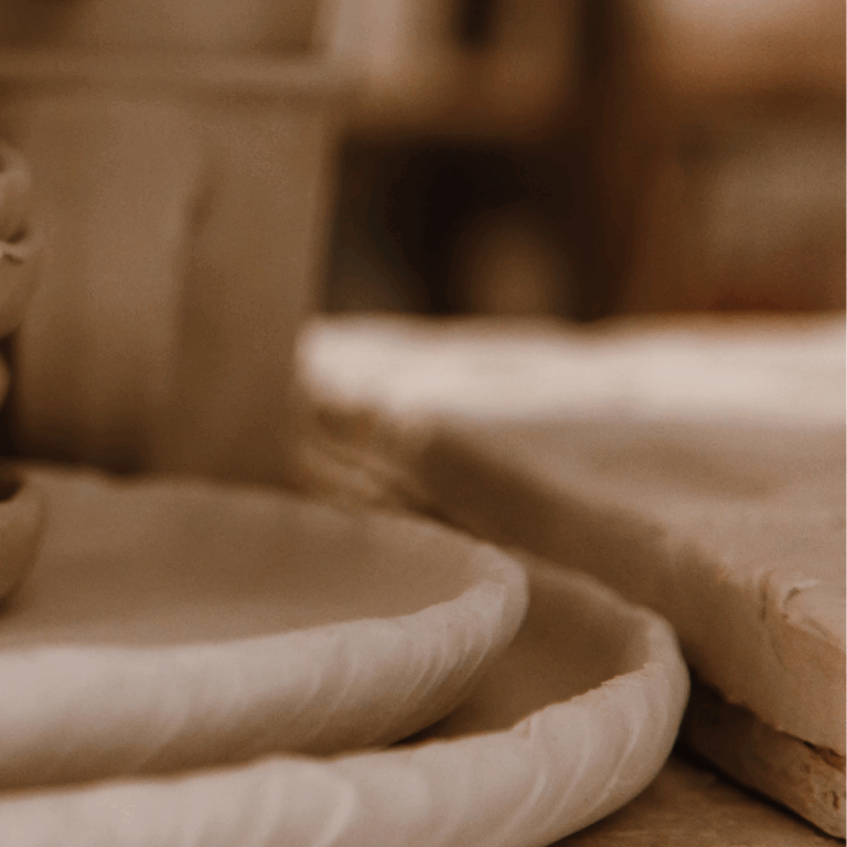 Close-up of handcrafted textured ceramic plates in a warm neutral-toned home setting