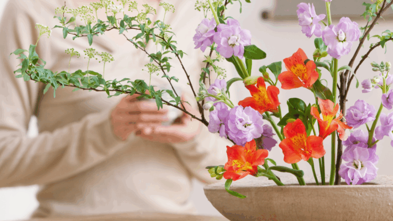 Vibrant flower arrangement with red and purple blooms in a ceramic bowl