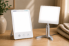Verilux HappyLight Luxe and Carex Day-Light Classic Plus light therapy lamps side-by-side on a wood desk.